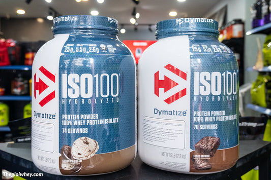 Dymatize ISO 100 5lbs — mặt trước hũ Cookies & Cream (74 servings) và Fudge Brownie (70 servings)